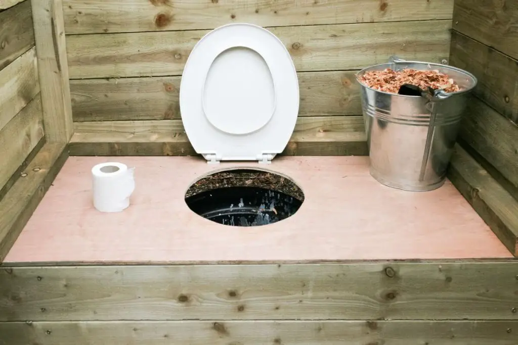 Una letrina de compostaje con virutas de madera y papel higiénico.